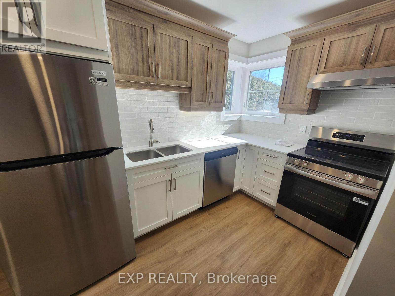 A kitchen with wooden cabinets and a stainless steel refrigerator.