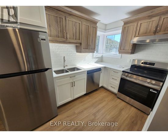 A kitchen with wooden cabinets and a stainless steel refrigerator.