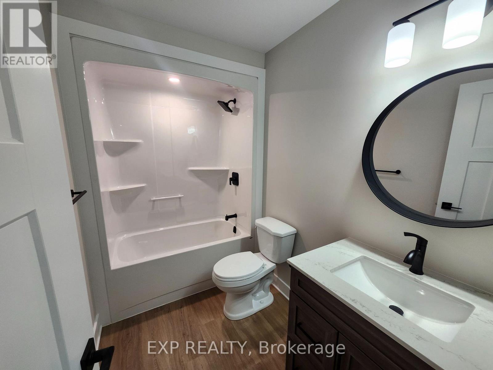 A bathroom with a toilet, sink, and a shower with a glass door.