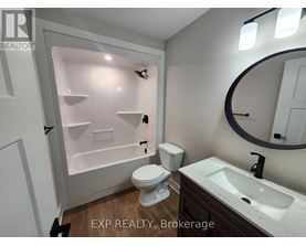 A bathroom with a toilet, sink, and a shower with a glass door.