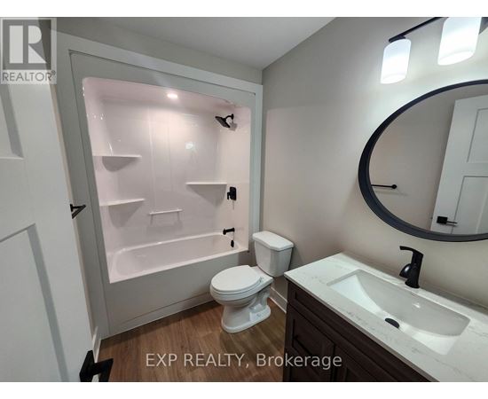 A bathroom with a toilet, sink, and a shower with a glass door.