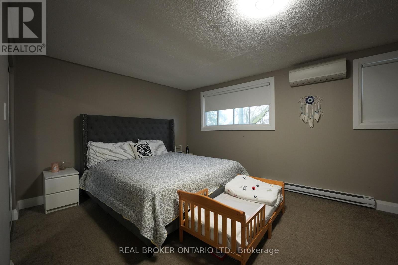 A bedroom with a bed, nightstand, and window.
