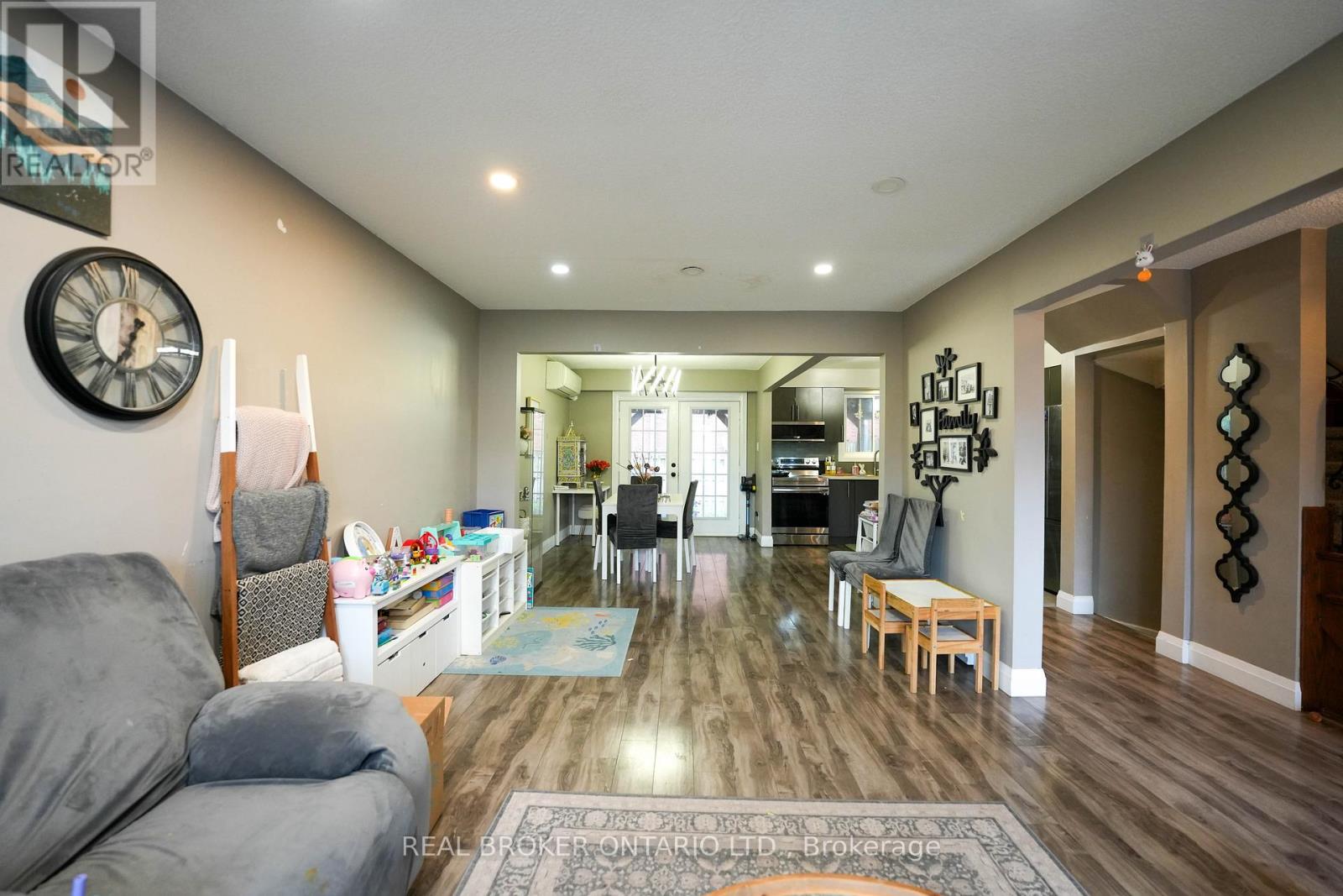 A modern kitchen with dark wood floors and a dining area with a table set for two.