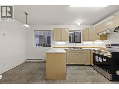 A kitchen with a black oven and wooden cabinets.