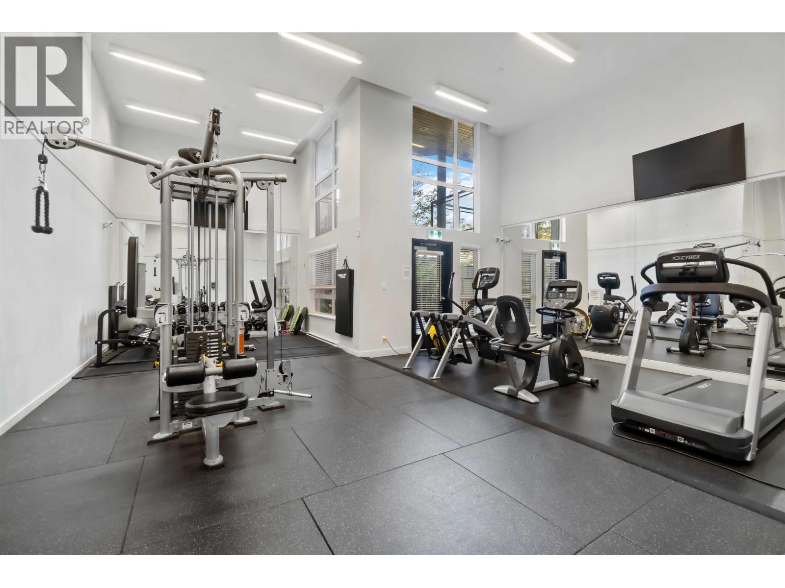 A well-equipped gym with various exercise machines and weights.