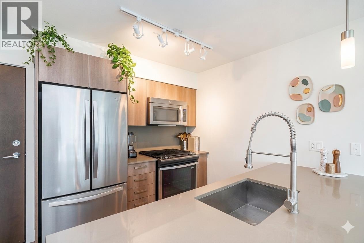 A modern kitchen with a stainless steel refrigerator and a sink.