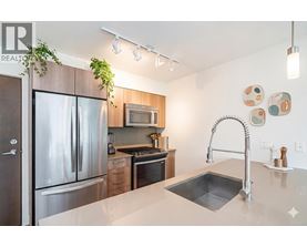 A modern kitchen with a stainless steel refrigerator and a sink.