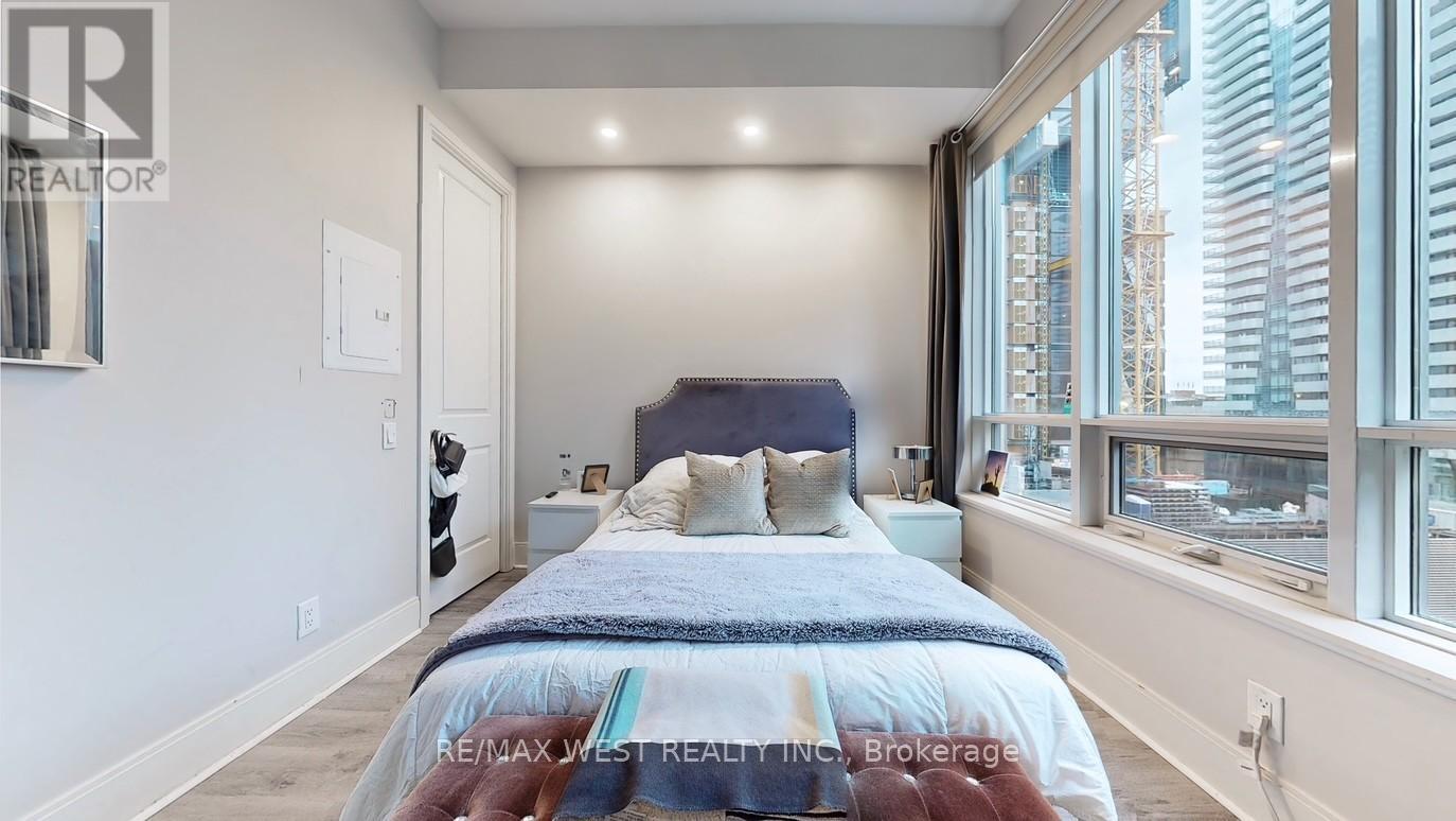A bedroom with a large bed and a window overlooking a cityscape.