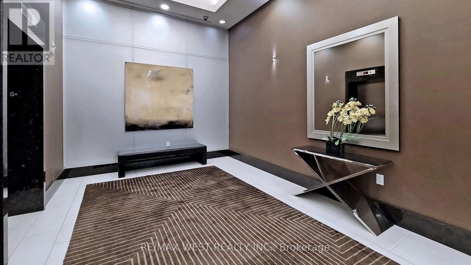 A room with a brown carpet and a painting on the wall.