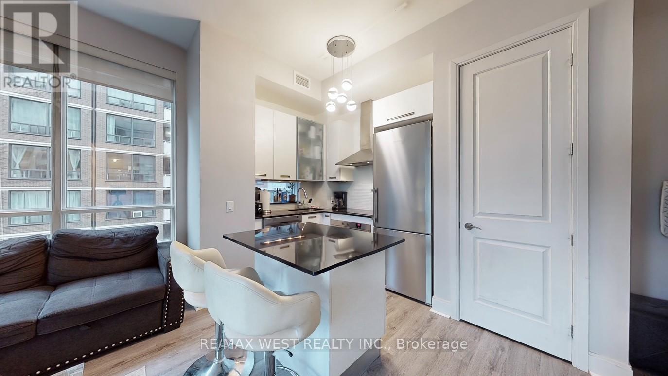 A modern kitchen with a glass table and white chairs.