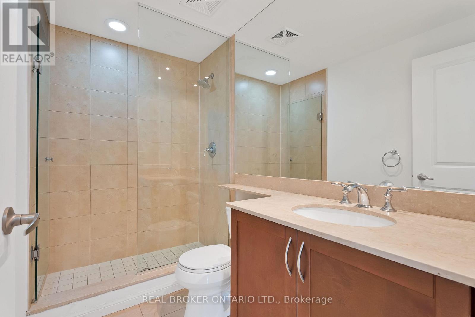 A bathroom with a walk-in shower and double sink vanity.