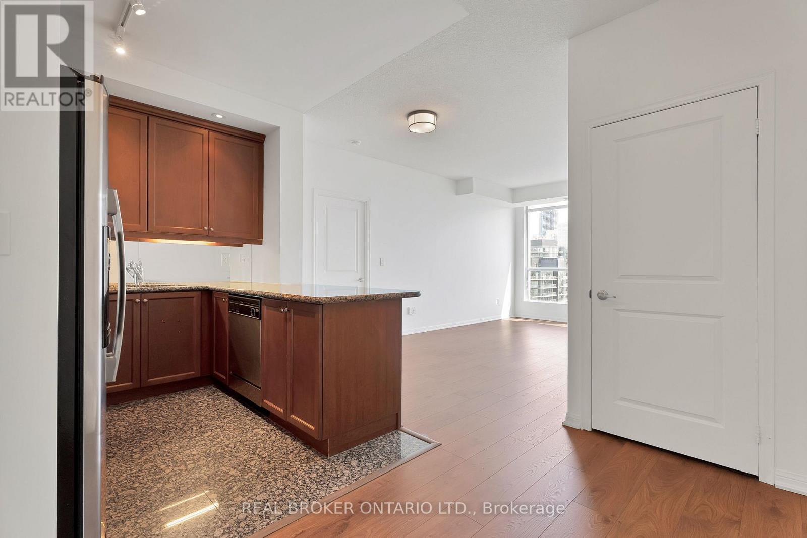 A kitchen with brown cabinets and a refrigerator.