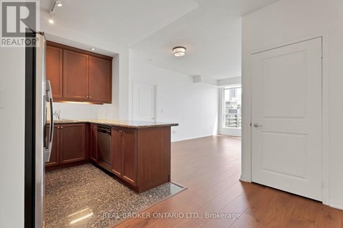 A kitchen with brown cabinets and a refrigerator.