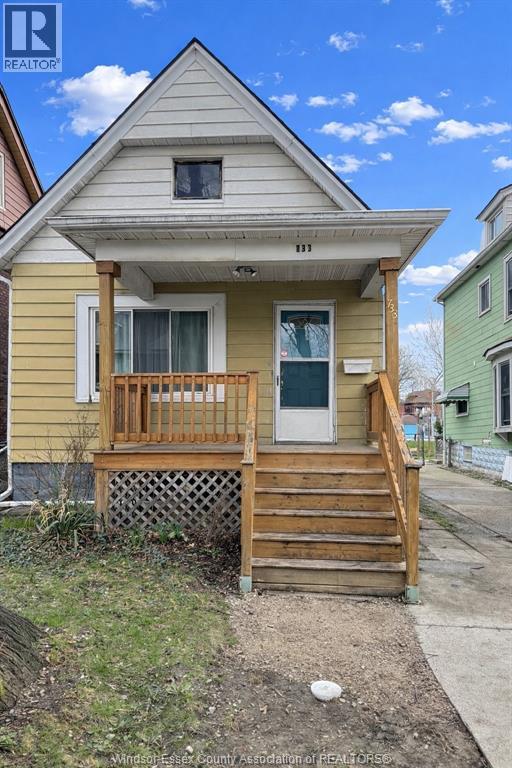 A small house with a porch and a front yard.