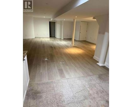 A room with wooden flooring and white walls.