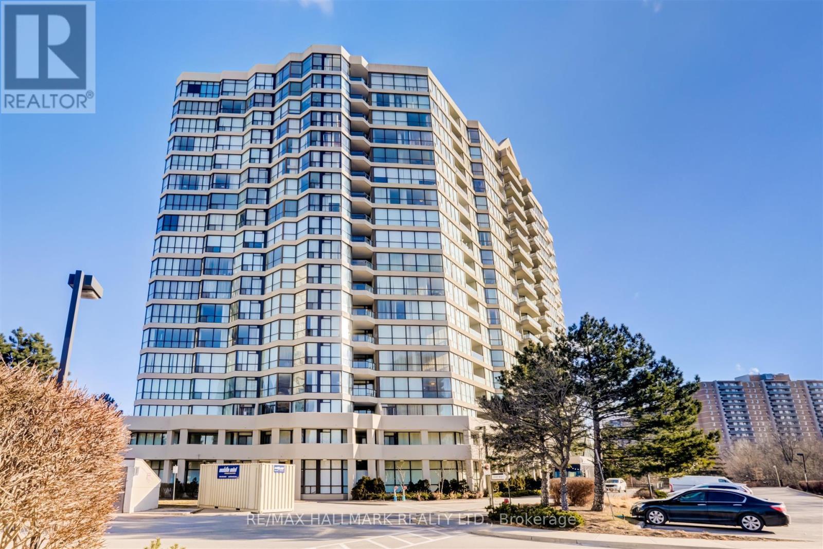 A tall building with many windows is the main focus of the image.