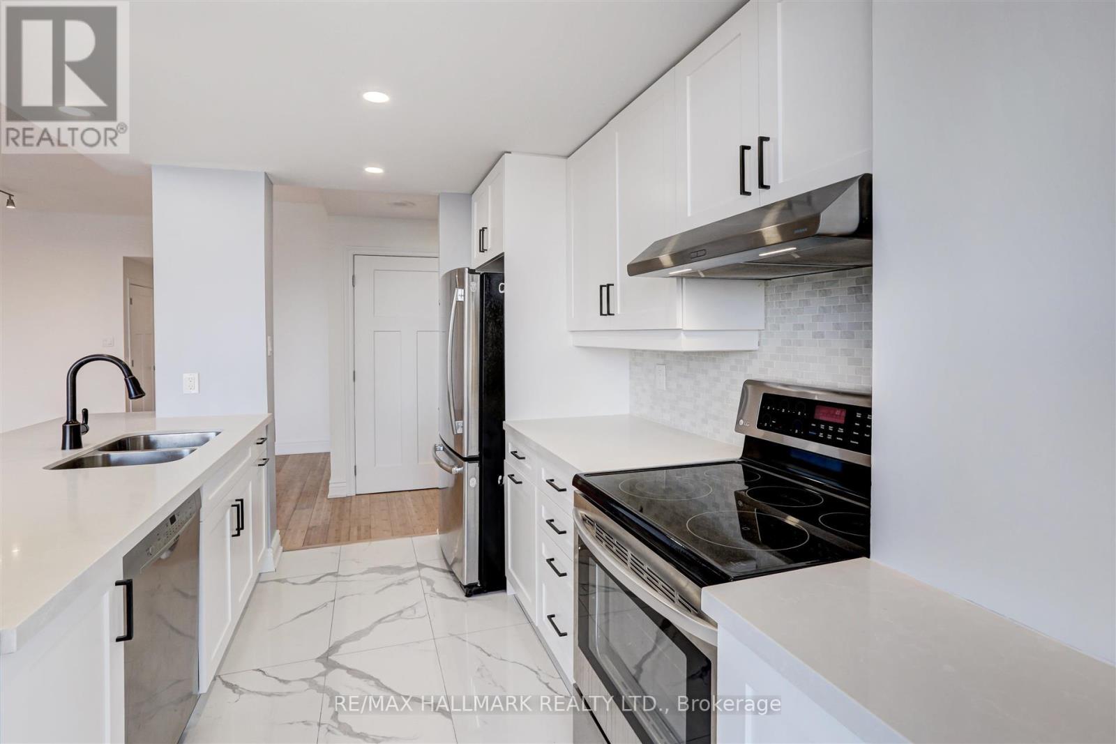 A modern kitchen with white cabinets and a black stove top oven.
