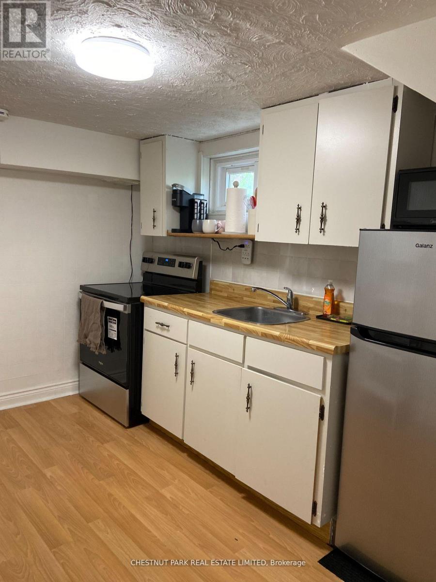 A kitchen with white cabinets and a wooden counter top.