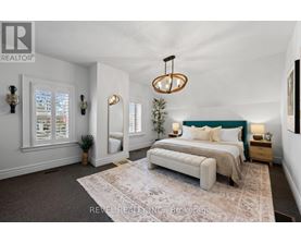 A bedroom with a large bed and a chandelier.