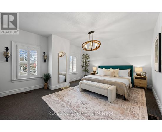 A bedroom with a large bed and a chandelier.