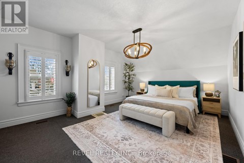 A bedroom with a large bed and a chandelier.