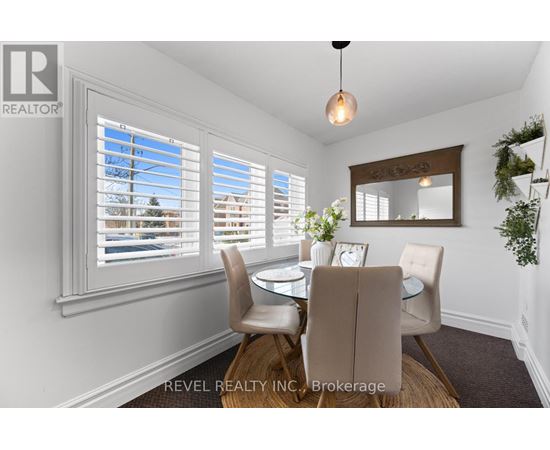A dining room with a table set for two and a view of the street outside.