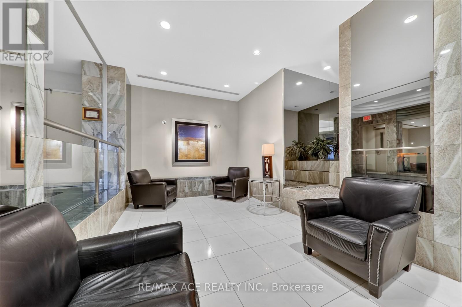A spacious waiting area with leather couches and a large mirror.