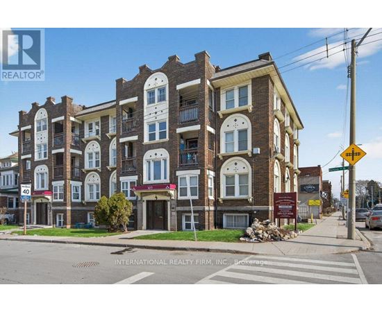 A street view of a multi-story building with a sign for International Realty Firm, INC. on the bottom.