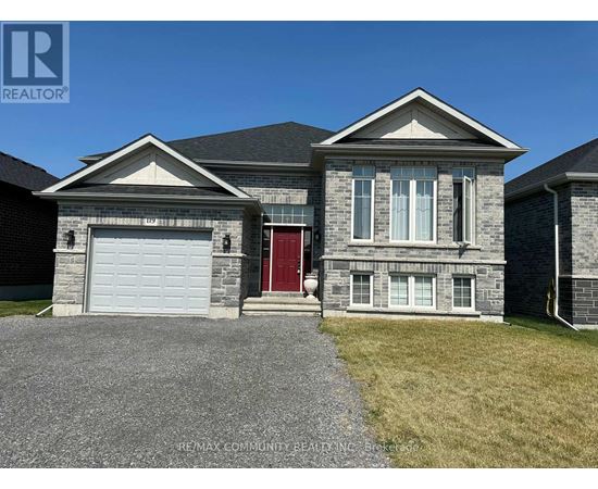 A house with a red door and a garage door is for sale.