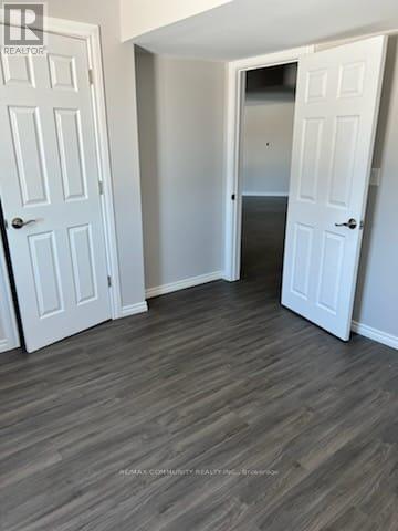 A room with two white doors and a wooden floor.