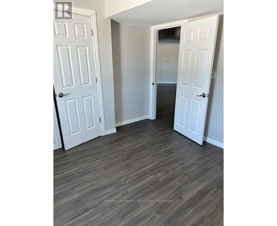 A room with two white doors and a wooden floor.