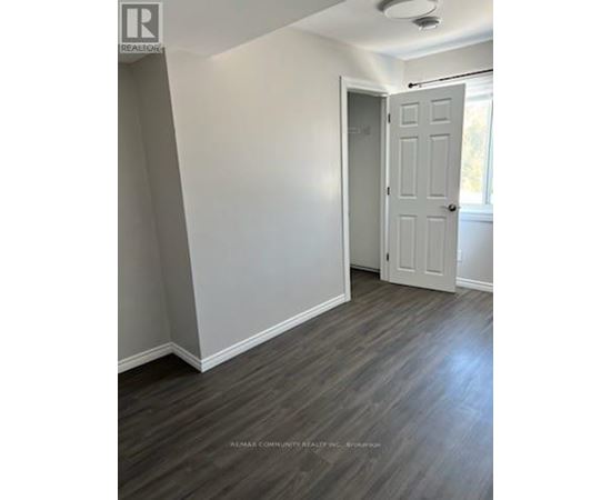 A room with a white door and grey walls.