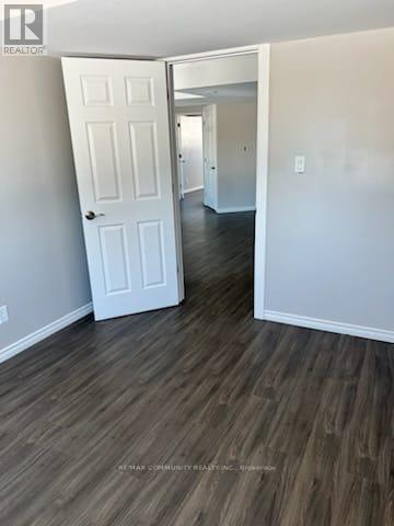 A white door is in a room with wood flooring.