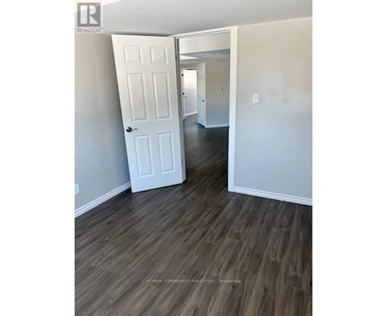 A white door is in a room with wood flooring.