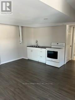 A kitchen with white cabinets and a black countertop.
