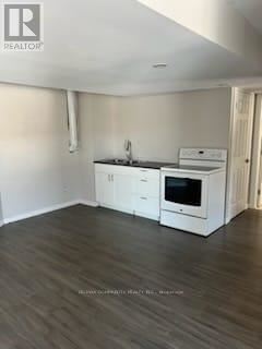 A kitchen with white cabinets and a black countertop.