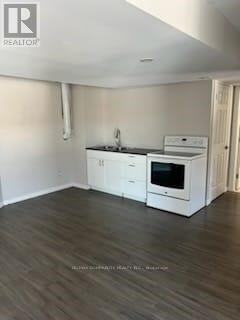 A kitchen with white cabinets and a black countertop.
