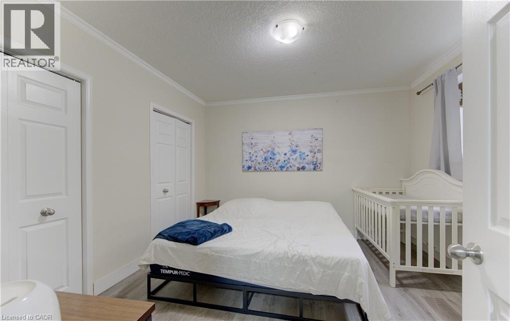 A bedroom with a white bed and a white crib.