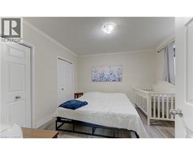 A bedroom with a white bed and a white crib.