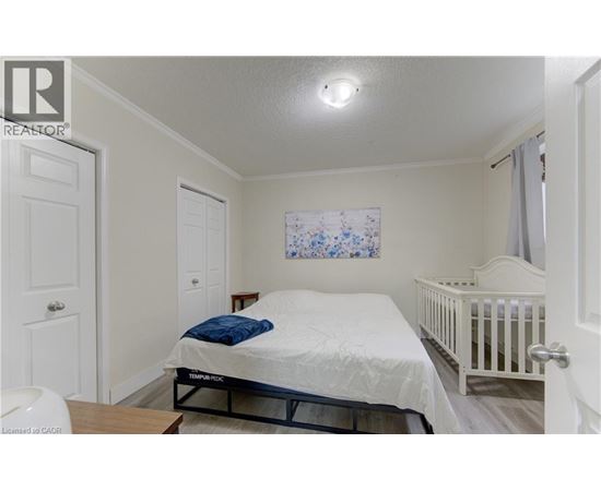 A bedroom with a white bed and a white crib.