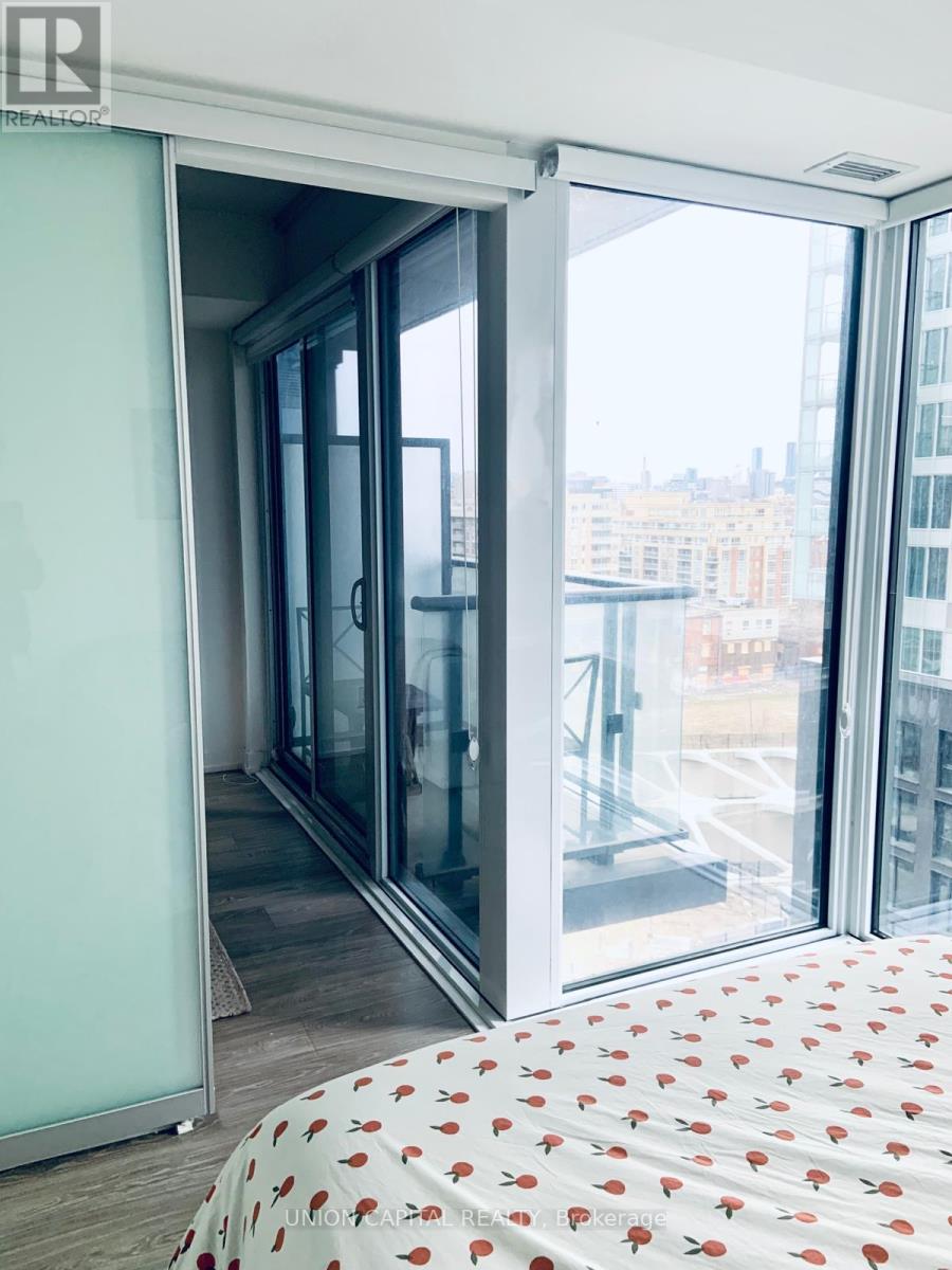 A bedroom with a bed and a sliding glass door.