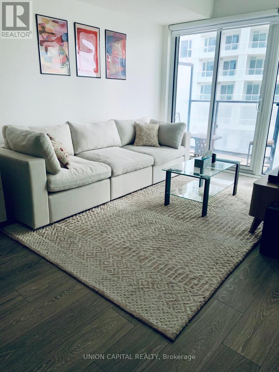 A living room with a couch, coffee table, and pictures on the wall.