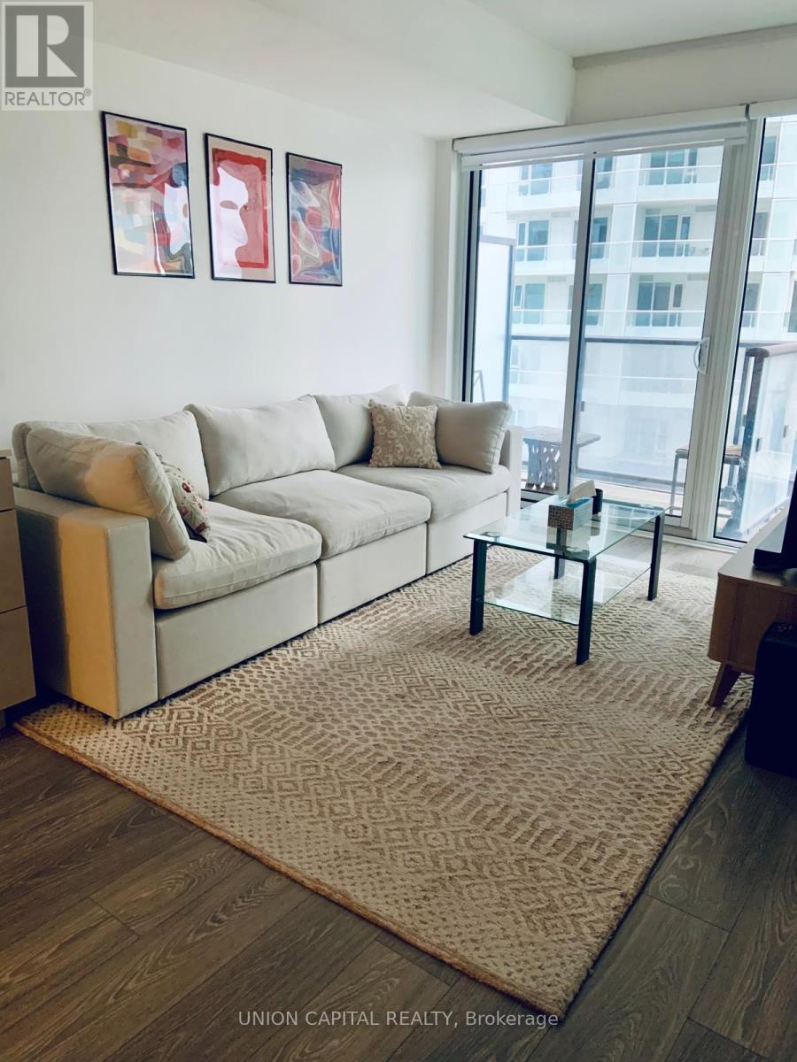 A living room with a couch, coffee table, and pictures on the wall.