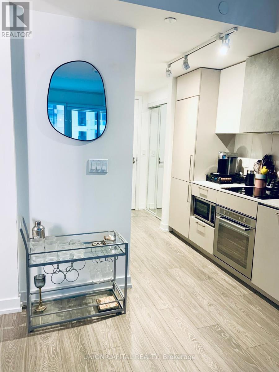 A modern kitchen with a glass table and stainless steel appliances.