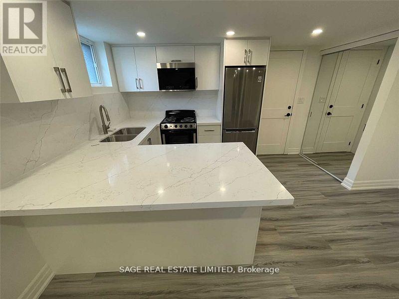 A white marble countertop in a modern kitchen with a refrigerator and cabinets.