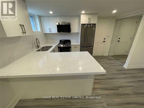 A white marble countertop in a modern kitchen with a refrigerator and cabinets.