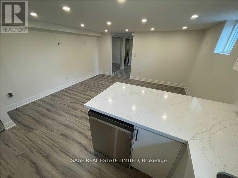 A spacious room with a marble countertop and wood flooring.