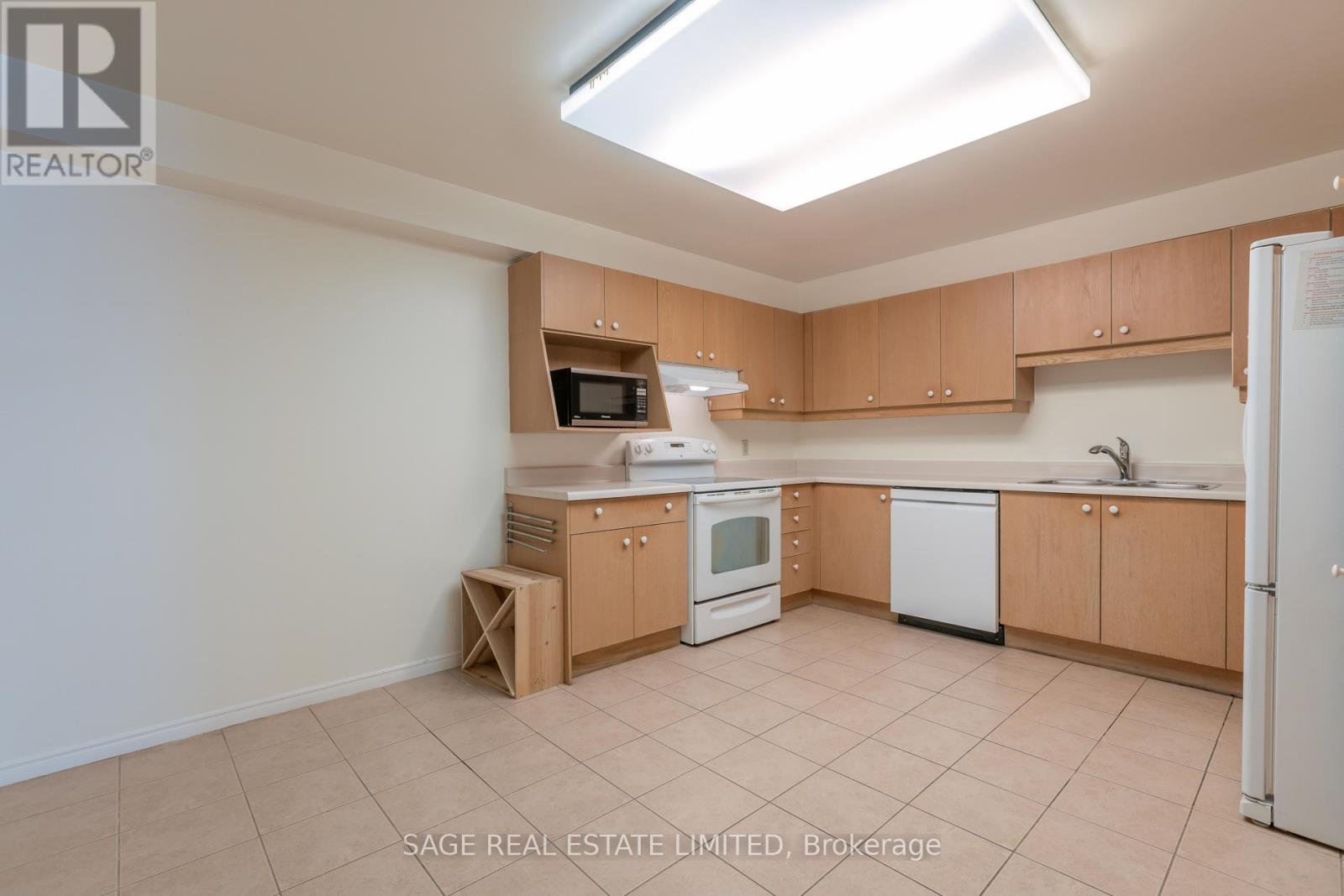 A kitchen with white appliances and wooden cabinets.