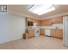 A kitchen with white appliances and wooden cabinets.