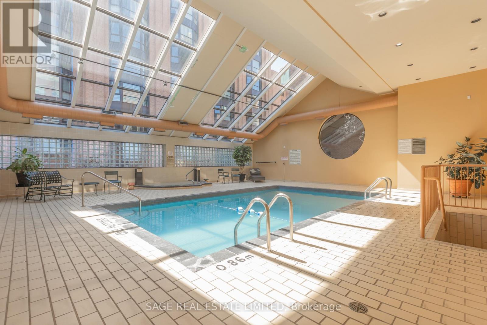 A large indoor swimming pool with a glass ceiling.